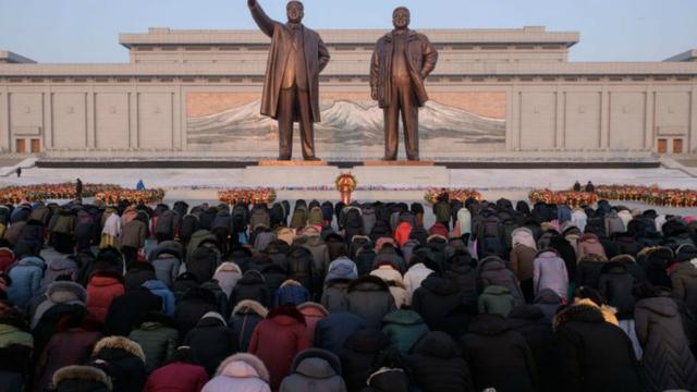Warga Korea Utara membungkuk di hadapan patung Kim Il-sung dan Kim Jong-il di Pyongyang, dalam perayaan HUT mendiang ayah Kim Jong-un itu pada 16 Februari 2019 (AFP PHOTO)