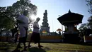 Umat ​​Hindu berjalan menuju Pura Jagat Natha untuk merayakan hari raya Galungan di Denpasar, Bali, Rabu (8/6/2022).  Hari Raya Galungan dan Kuningan merupakan hari besar suci umat Hindu yang jatuh setiap enam bulan sekali. (SONNY TUMBELAKA / AFP)