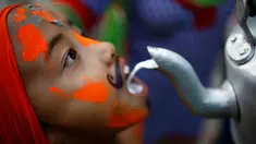 Seorang bocah membuka mulutnya untuk meminum susu saat perayaan Gaijatra Festival atau Festival Sapi di Kathmandu, Nepal, Jumat (19/8). Umat Hindu di Kathmandu merayakan Festival Sapi untuk meminta keselamatan dan kedamaian. (REUTERS/ Navesh Chitrakar)