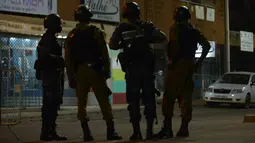 Sejumlah aparat kepolisian dan militer berpatroli di lokasi serangan oleh sekolompok orang bersenjata di sebuah kafe di Ouagadougou, Burkina Faso (13/8). Tiga orang bersenjata secara brutal menembaki pengunjung restoran. (AFP Photo/Ahmed Ouoba)