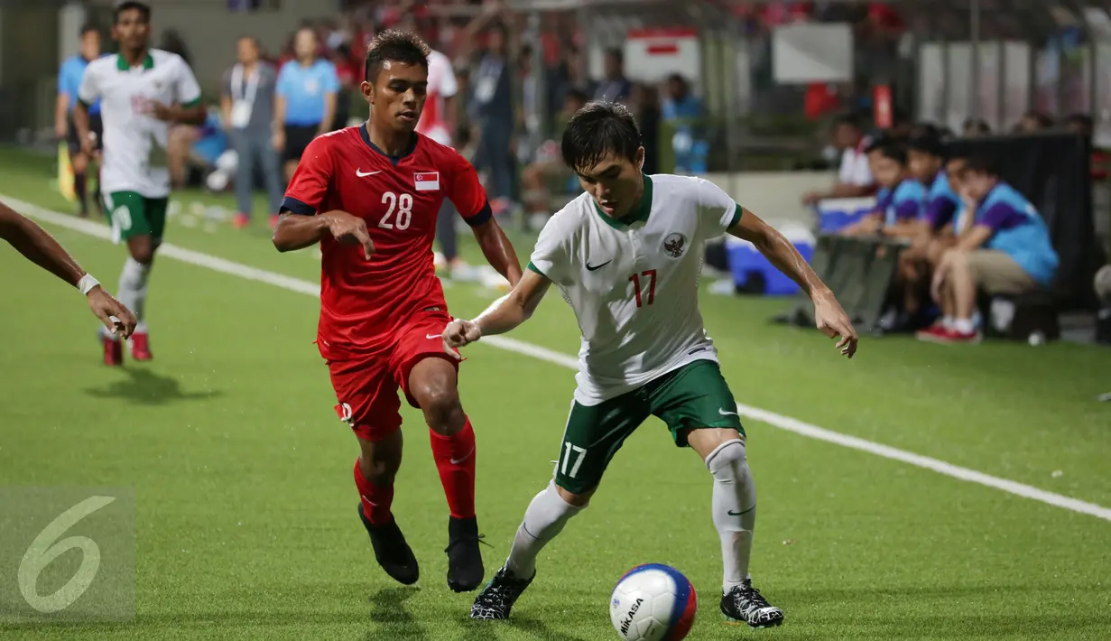 Gelandang timnas Indonesia U-23, Paolo Sitanggang (kanan) berusaha melewati Safirul Sulaiman (Singapura) di laga penyisihan Grup A SEA Games 2015 di Stadion Jalan Besar Singapura, Kamis (11/6/2015). Indonesia unggul 1-0. (Liputan6.com/Helmi Fithriansyah)