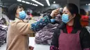 Karyawan diukur suhu badannya di Hangzhou Jiefeng Garments Co. Ltd., Hangzhou, Provinsi Zhejiang, China, Rabu (12/2/2020). Di bawah arahan dan dukungan otoritas setempat, banyak perusahaan di Zhejiang kembali beroperasi setelah melakukan pencegahan dan pengendalian wabah virus corona. (Xinhua/Xu Yu)