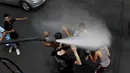 Personel dinas Kota Amman menyemprot sejumlah anak dengan sprinkler air untuk mengurangi efek dari gelombang panas di Yordania, Senin(3/8/2015). (REUTERS/Muhammad Hamed)