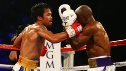 Petinju Manny Pacquiao (kiri) saat melayangkan pukulan kepada lawannya Timothy Bradley di MGM Grand Garden Arena, Las Vegas, AS, (9/4). (Mark J. Rebilas-USA TODAY Sports)