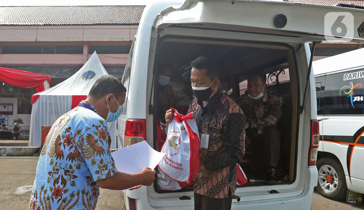 Pelaku transportasi menerima bantuan presiden seusai vaksinasi di Terminal Kampung Rambutan, Jakarta, Kamis (10/6/2021). Vaksinasi massal ini untuk 1.000 orang yang terdiri dari para supir bus, kernet, pedagang usaha kecil dan mikro di Terminal Kampung Rambutan. (Liputan6.com/Herman Zakharia)