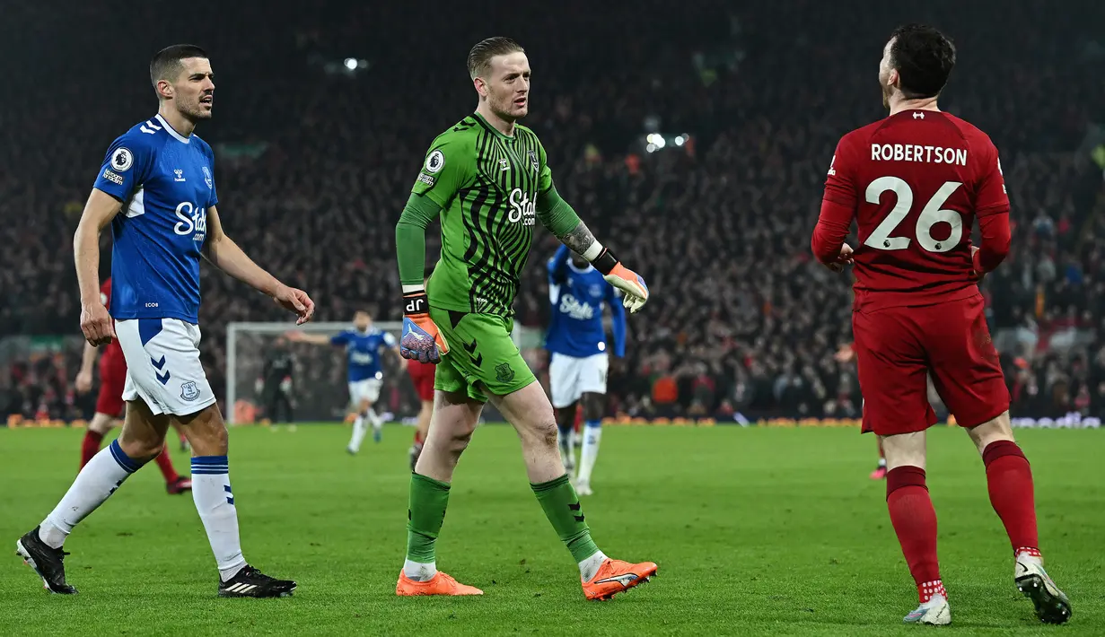 Kiper Everton, Jordan Pickford, menghampiri pemain Liverpool, Andrew Robertson, pada laga Liga Inggris di Stadion Anfield, Selasa (14/2/2023). Pickford menghampiri Robertson lantaran geram karena sang bek kedapatan menggiring bola ketika pluit sudah berbunyi tanda adanya pelanggaran. (AFP/Paul Ellis)