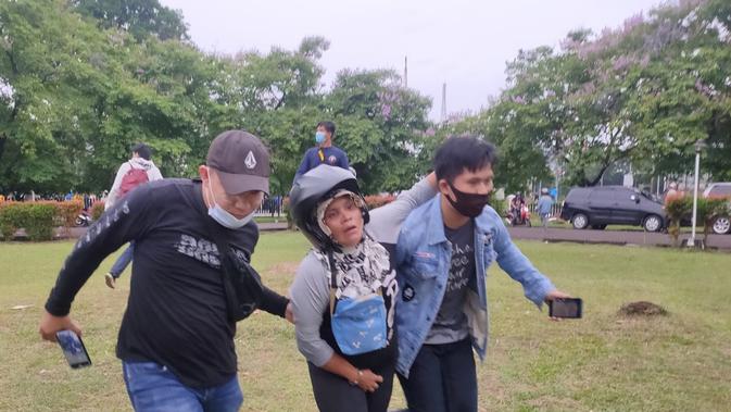 Dua orang mahasiswa di Palembang membantu salah satu pedagang menyelamatkn diri dari amukan pendemo (Liputan6.com / Nefri Inge)