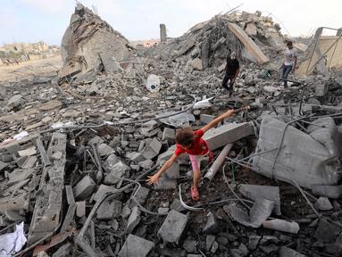 Seorang anak perempuan Palestina mencari jalan di antara reruntuhan bangunan yang dihantam serangan Israel di kamp pengungsi Bureij, Jalur Gaza tengah pada 10 Juli 2025. (Eyad BABA/AFP)