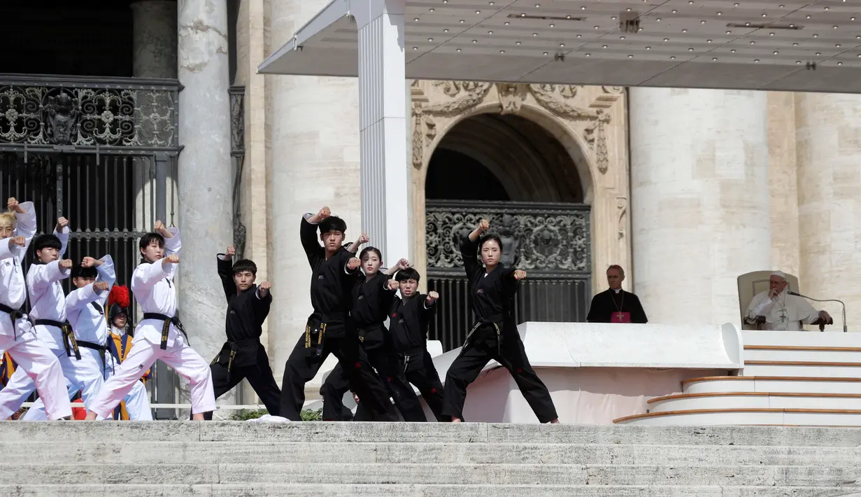 Atlet Taekwondo dari Korea Selatan membentuk formasi melakukan atraksi di depan Paus Fransiskus saat pertemuan umum mingguan di Lapangan Santo Petrus, Vatikan (30/5). (AP Photo/Gregorio Borgia)