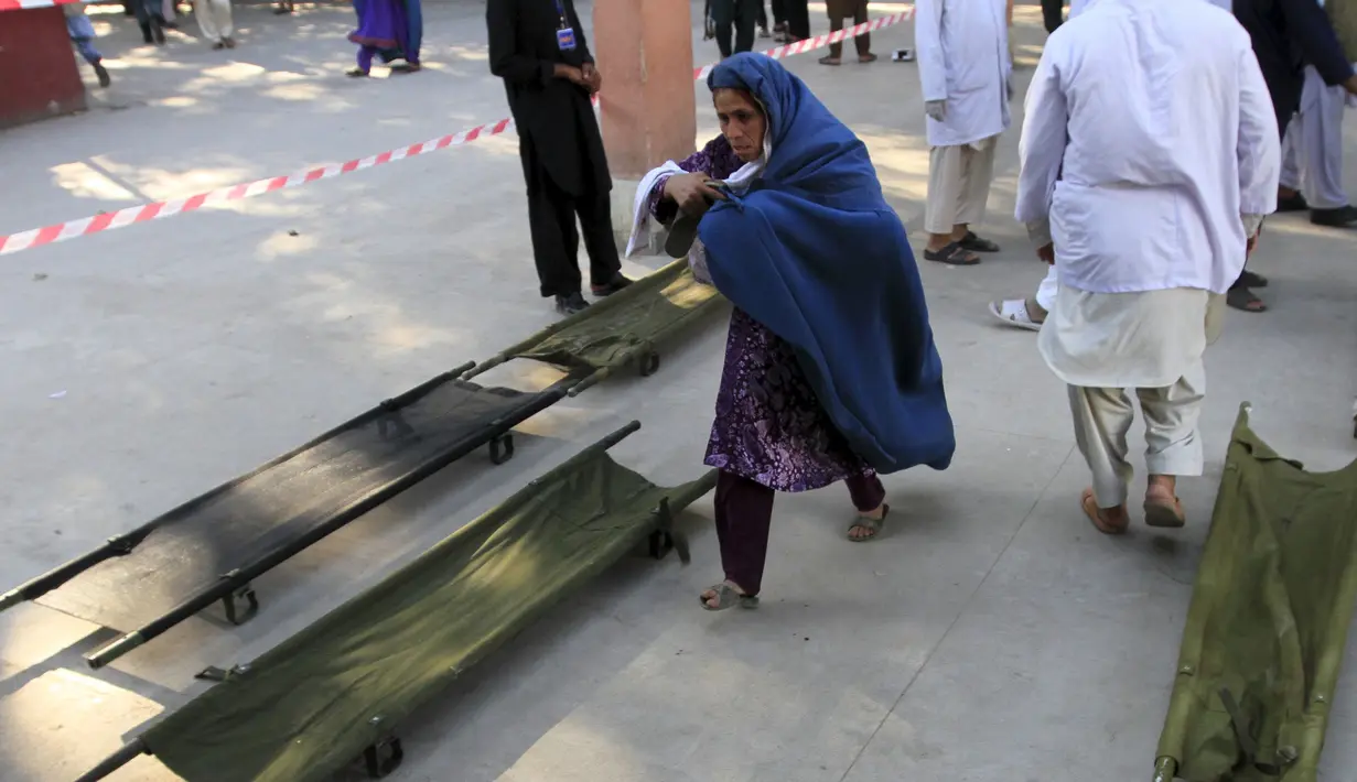 Seorang wanita berlari menuju RS untuk melihat keadaan anaknya usai terjadi gempa yang menghantam Jalalabad, Afghanistan, Senin (26/10/2015). Sekitar 43 orang dipastikan tewas akibat lindu berkekuatan 7,5 skala Richter tersebut. (REUTERS/Parwiz)