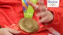 Medali emas bulutangkis Olimpiade Rio 2016 yang diraih Liliyana Natsir saat hadir dalam acara Liputan 6 SCTV di Studio SCTV, SCTV Tower, Jakarta, Kamis (25/8/2016). (Bola.com/Arief Bagus)