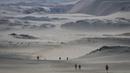 Para peserta berjalan saat mengikuti lomba marathon sejauh 250 kilometer di Gurun Ica, Kamis (30/11/2017). Marathon yang terbagi dalam enam tahapan ini diprediksi akan berakhir pada 4 Desember. (AFP/Jean-Philippe Ksiazek)