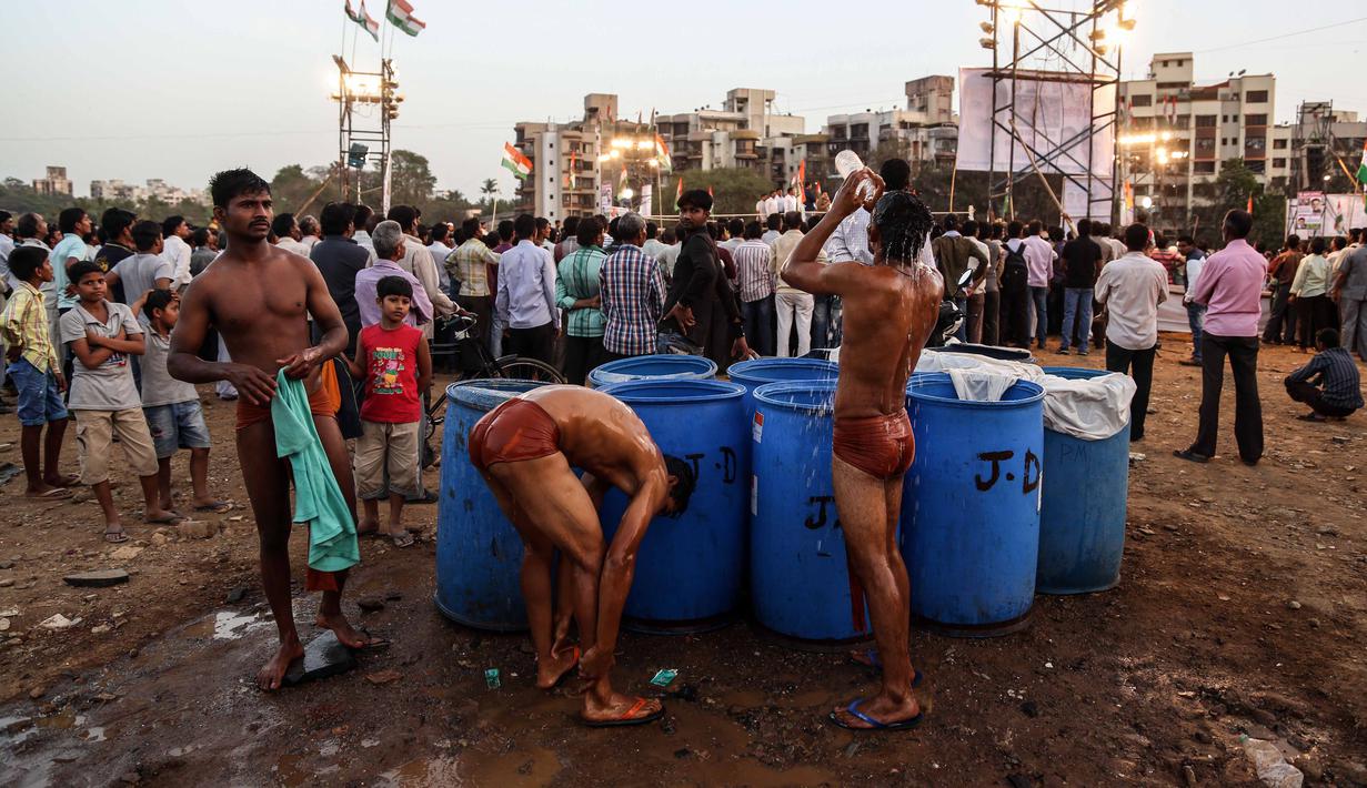 Pegulat membersihkan badan usai berlaga pada ajang Indian traditional wrestling competition atau Kushti di Arena Akhara, Mumbai, India, 20 Maret 2016. Olahraga tradisional ini terus dilestarikan sebagai bagian dari budaya. (EPA/Divyakant Solanki)