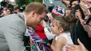 Pangeran Harry menyapa seorang bocah pemberi selamat di luar Kastil Windsor, Inggris, Jumat (18/5). Pangeran Harry dan Meghan Markle akan menikah pada 19 Mei 2018. (Ben Birchall/PA via AP)