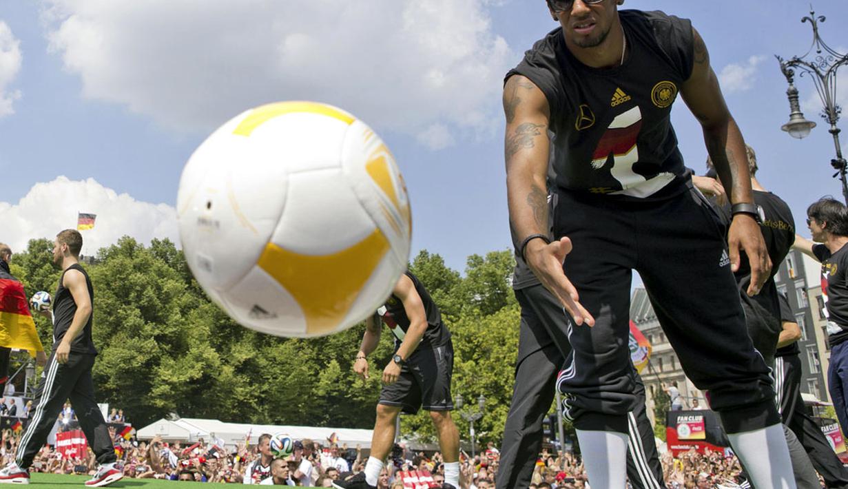 Pemain Timnas Jerman, Jerome Boateng, melemparkan bola ke arah para suporter yang ikut merayakan kemenangan Der Panzer, Berlin, (15/7/2014). (REUTERS/Axel Schmidt)