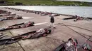 Seorang pria berjalan di antara paus pilot di dermaga di Jatnavegur, dekat Vagar, Kepulauan Faroe, Denmark, Rabu (22/8). Penangkapan paus pilot di Kepulauan Faroe adalah legal dan sudah menjadi tradisi. (MADS CLAUS RASMUSSEN/RITZAU SCANPIX/AFP)