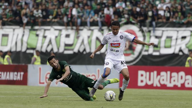 Penyerang Persebaya Surabaya, Manuchekhr Dzhalilov, terjatuh saat berebut dengan pemain Arema FC, Dendi Santoso, pada laga final Piala Presiden 2019 di Stadion Gelora Bung Tomo, Selasa (9/4). Kedua tim bermain imbang 2-2. (Bola.com/Yoppy Renato)