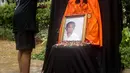Sumarsih melakukan tabur bunga pada foto anaknya, Bernardus Realino Norma Wirawan atau Wawan yang tewas dalam tragedi Semanggi Satu selama peringatan 21 Tahun tragedi tersebut di halaman Universitas Atma Jaya, Jakarta, Rabu (13/11/2019). (Liputan6.com/Faizal Fanani)