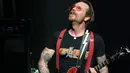 Aksi Jesse Hughes, vokalis grup rock Eagles of Death Metal, pada konser perdana mereka setelah serangan Paris pada November 2015 lalu, di gedung teater Olympia, Paris, Selasa (16/2). (AFP PHOTO/Joel SAGET)