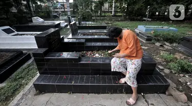 Keluarga membersihkan makam saat ziarah di kompleks pemakaman Gereja Tugu, Semper, Jakarta, Senin (23/12/2019). Ziarah menjadi tradisi keluarga keturunan Portugis di Kampung Tugu menjelang Hari Raya Natal. (merdeka.com/Iqbal Nugroho)