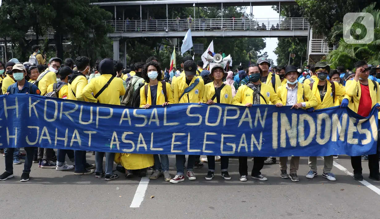 Mahasiswa membentangkan spanduk saat melakukan aksi unjuk rasa di sekitar kawasan Patung Kuda, Jalan Medan Merdeka Barat, Jakarta, Selasa (20/10/2020). Dalam aksinya, ratusan mahasiswa meminta pemerintah membatalkan pengesahan Omnibus Law UU Cipta Kerja. (Liputan6.com/Helmi Fithriansyah)