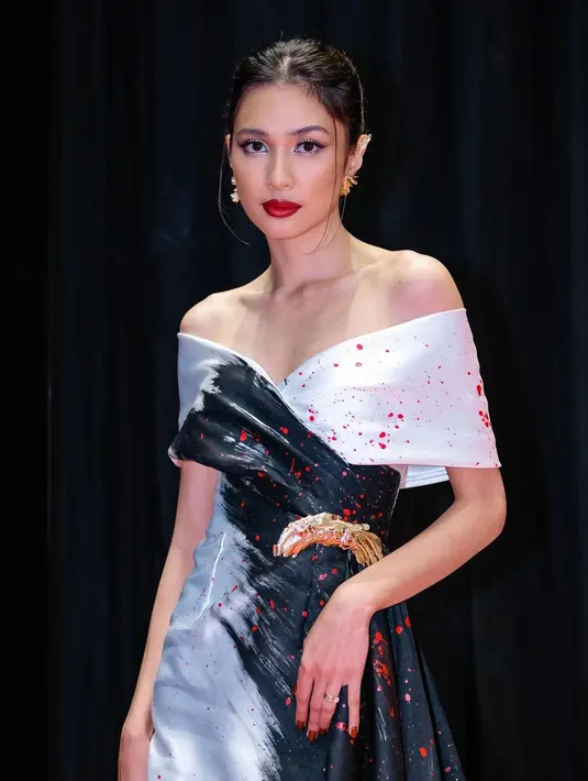 OOTD luar biasa lainnya dari Mikha Tambayong dibalut gaun malam. Off-the-shoulder dress ini memiliki detail train panjang yang menjuntai hingga ke lantai. Nuansa hitam-putih diberi sendikit sentuhan warna merah untuk kesan dramatis. Foto: Instagram.