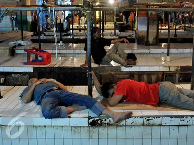 Pedagang tertidur di atas meja kios daging yang kosong di Pasar Palmerah, Jakarta, Senin (10/8/2015). Pedagang daging sapi melakukan aksi mogok jualan karena harga daging terus merangkak naik hingga mencapai Rp 130 ribu/kg. (Liputan6.com/Johan Tallo)