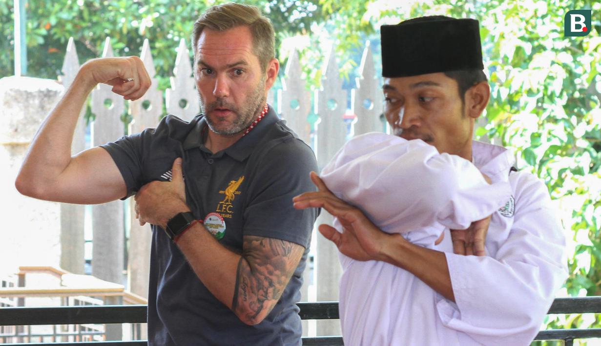 Legenda Liverpool, Jason McAteer belajar seni beladiri khas budaya Betawi, silat saat mengunjungi di Setu Babakan, Jakarta, Jumat (9/3/2018). Kegiatan ini dalam rangkaian LFC World Tour Jakarta. (Bola.com/Asprilla Dwi Adha)