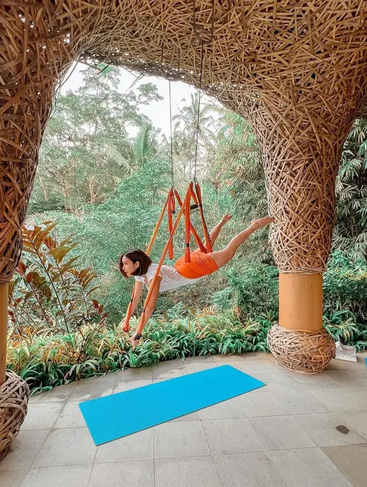 Gisela juga menekuni yoga, seperti terlihat dalam foto ini. Mengenakan outfit santai berwarna putih, Gisela memamerkan beberapa pose Aerial Yoga. Foto: Instagram.