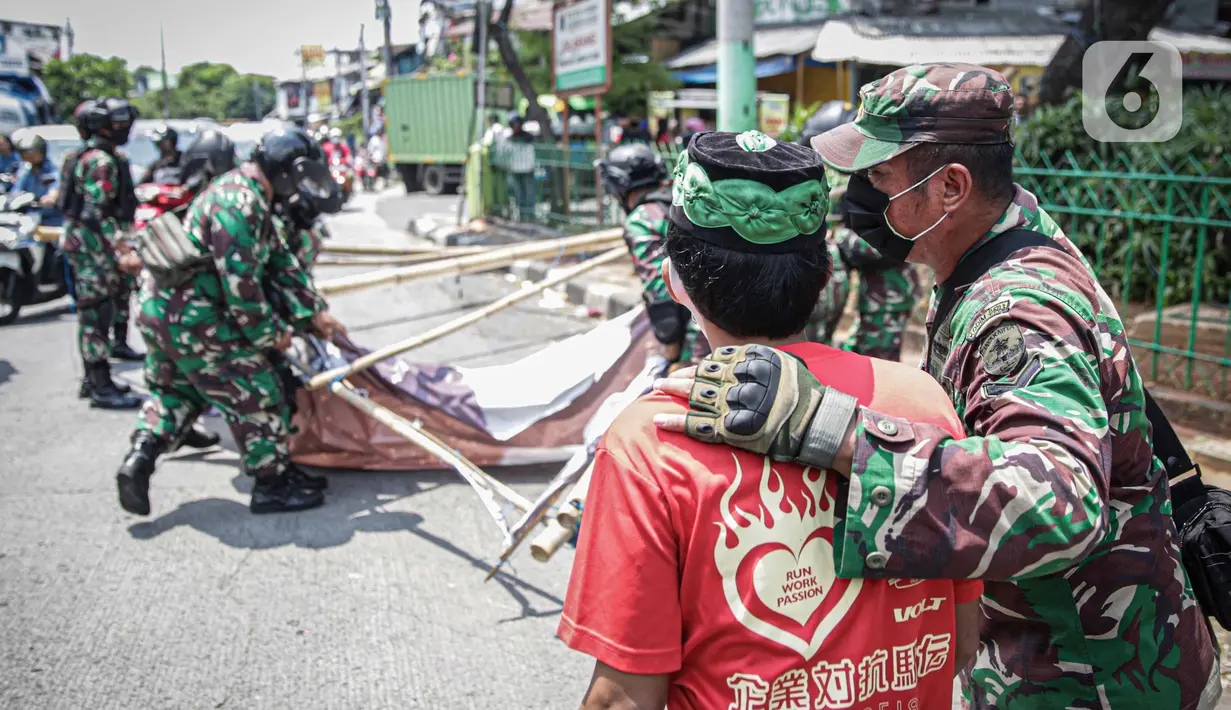 Anggota TNI berbicara dengan seorang warga yang meminta untuk tidak mencopot paksa baliho Rizieq Shihab di sekitar kawasan Petamburan, Jakarta, Jumat (20/11/2020). Pencopotan dilakukan karena menyalahi aturan yang telah ditetapkan. (Liputan6.com/Faizal Fanani)