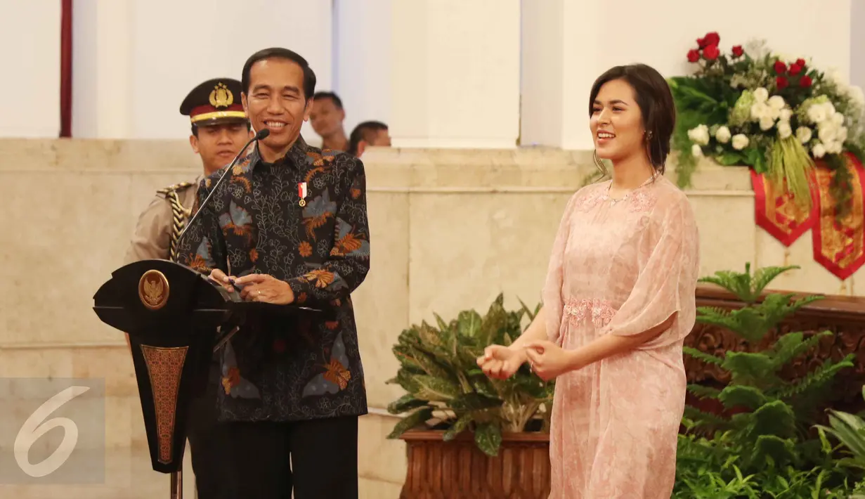Presiden Jokowi dan penyanyi Raisa bernyanyi bersama saat merayakan Hari Musik Nasional 2017 di Istana Negara, Jakarta, Kamis (9/3). Acara ini dihadiri oleh para penyanyi-penyanyi ternama Indonesia. (Liputan6.com/Angga Yuinar)