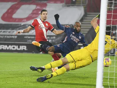 Pemain Arsenal Alexandre Lacazette (tengah) mencetak gol ke gawang Southampton pada pertandingan Liga Inggris di Stadion St Mary, Southampton, Inggris, Selasa (26/1/2021). Arsenal menang 3-1 atas Southampton. (Andy Rain/Pool via AP)