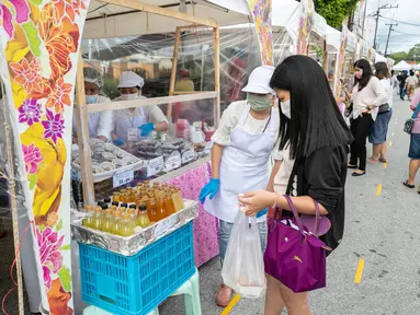 Para penjual menawarkan minuman kepada pelanggan dalam festival kuliner di kota tua Phuket, Thailand (13/9/2020). Festival selama dua hari itu digelar untuk mendorong pariwisata dan perekonomian setempat. (Xinhua/Zhang Keren)