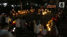 Sejumlah relawan menyalakan lampu pada malam renungan Hari AIDS Sedunia di Tanah Abang, Jakarta, Rabu (1/12/2021). Acara ini mengampanyekan kepada masyarakat untuk mewaspadai penularan virus HIV/AIDS dan lebih berempati pada penderitanya. (Liputan6.com/Herman Zakharia)