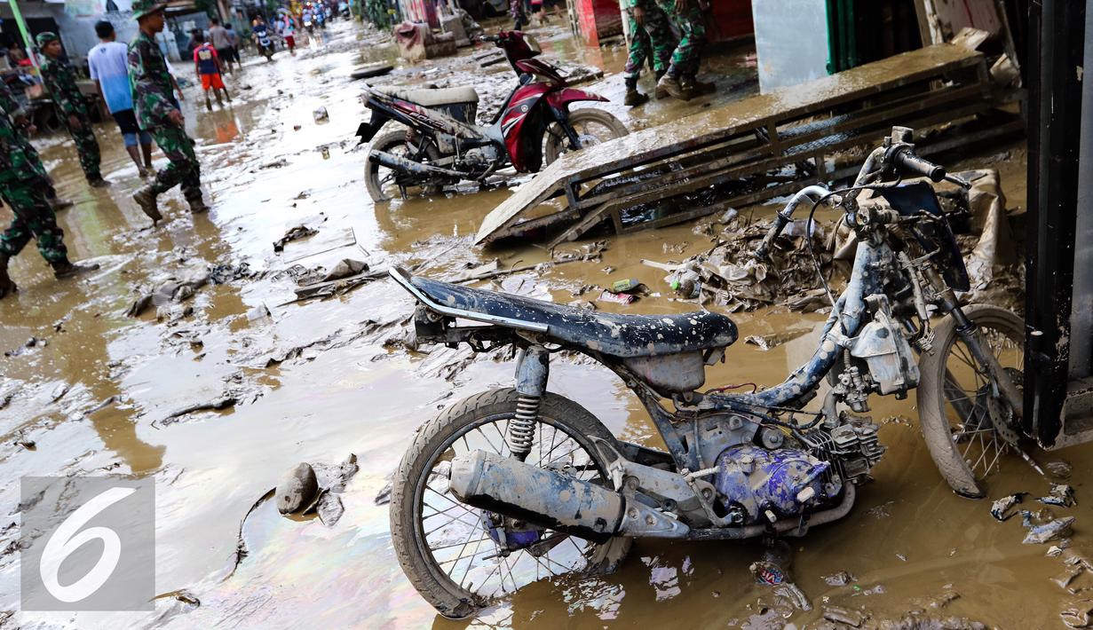 Sebuah sepeda motor dilumuri lumpur usai banjir menggenangi komplek Pondok Gede Permai Jatiasih, Bekasi, Jumat (22/04). (Liputan6.com/Fery Pradolo)