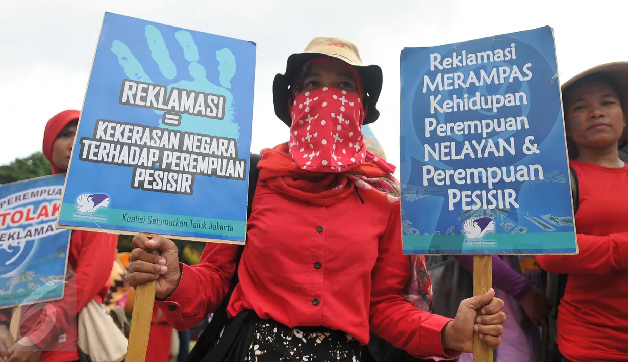 Seorang massa memegang poster saat aksi long march menuju Istana Presiden, Jakarta, Selasa (8/3). Aksi memperingati Hari Perempuan Internasional ini menuntut pemerintah memberikan perlindungan terhadap perempuan Indonesia. (Liputan6.com/Gempur M Surya)