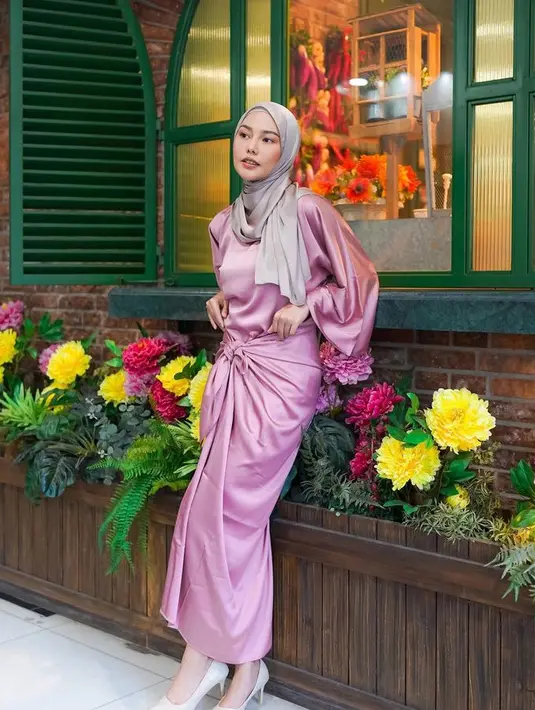 Bergaya barbiecore saat lebaran seperti Dara dengan mengenakan kaftan warna pink model silk. Dipadukan kerudung coklat lilit. [@daraarafah]