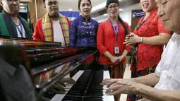 Seorang pasien (kanan) memainkan piano bersama karyawan saat Hari Kartini di RS Siloam TB Simatupang, Jakarta, Sabtu (21/4). Kegiatan ini mengenang Kartini sebagai pahlawan wanita dalam memperjuangkan emansipasi wanita. (Liputan6.com/Fery Pradolo)