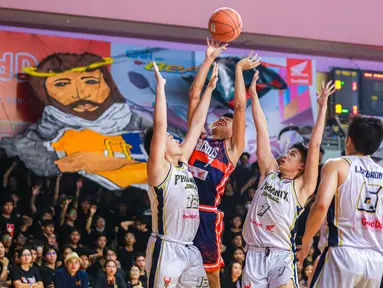 Pebasket SMA Kolese Kanisius Jakarta, Gregorio Marcus Rahardjo (tengah kiri) berusaha memasukkan bola ke ring pada laga final DBL 2023/2024 Seri Jakarta Utara dan Jakarta Pusat melawan SMA Jubilee di GOR Cempaka Putih, Jakarta Pusat, Jumat (18/08/2023). (Bola.com/Bagaskara Lazuardi)