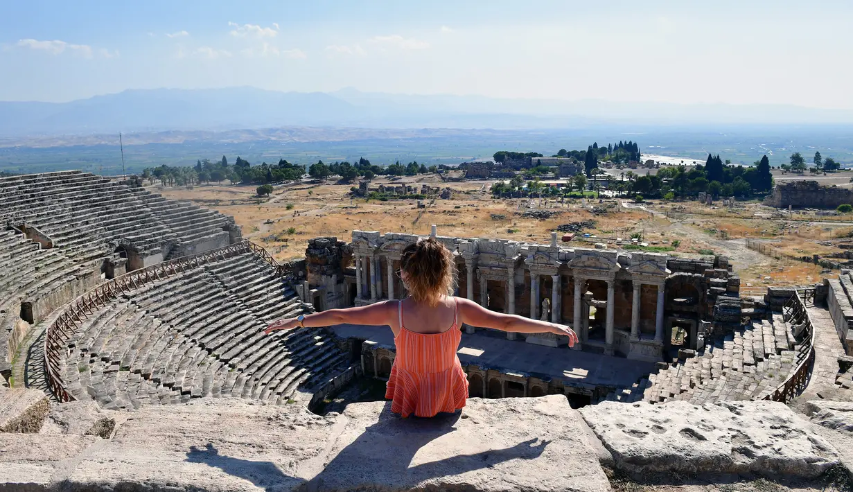 Seorang pengunjung duduk di reruntuhan kota kuno Hierapolis, Denizli, Turki, 6 Agustus 2020. Reruntuhan Hierapolis telah terdaftar sebagai Situs Warisan Dunia UNESCO. (Xinhua/Mustafa Kaya)