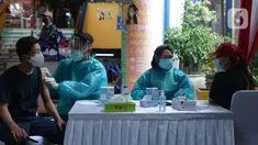 Polisi menyuntikkan vaksin virus corona COVID-19 kepada pedagang Pasar Induk Kramat Jati di Jakarta Timur, Kamis (22/7/2021). Sebanyak 250 pedagang Pasar Induk Kramat Jati menjalani vaksinasi guna menekan penyebaran COVID-19. (merdeka.com/Imam Buhori)
