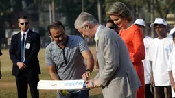 Pemain kriket India Virendar Shehwag mengajarkan Raja Philippe dan Ratu Belgia Mathilde bermain kriket di Oval Maidan di Mumbai, India, Jumat, (10/11). (AP Photo / Rajanish Kakade)