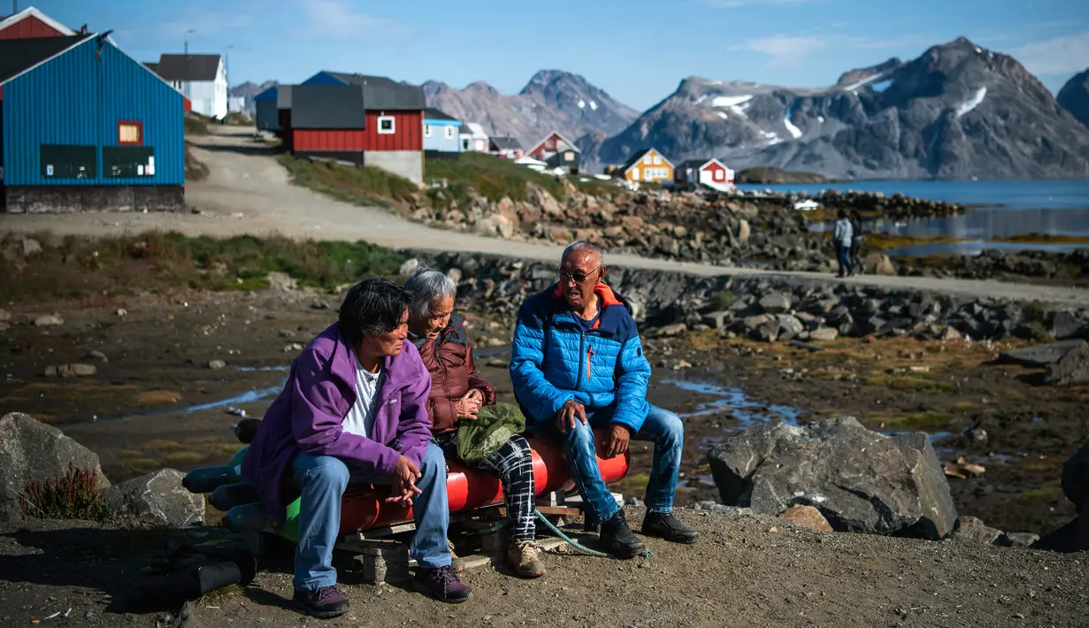 Penduduk mengobrol di Desa Kulusuk, Kota Sermersooq, Greenland, Denmark, 16 Agustus 2019. Sebagian besar penduduk Desa Kulusuk bekerja di sektor pariwisata dan perikanan lokal. (Jonathan NACKSTRAND/AFP)