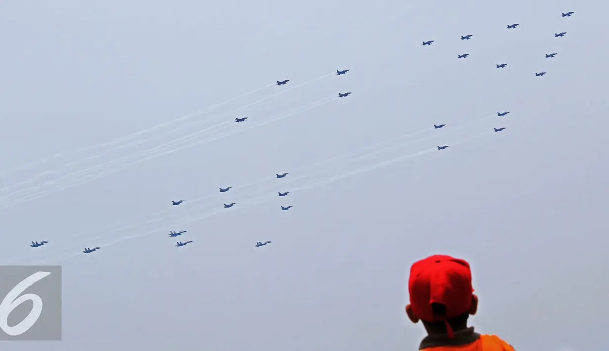Seorang warga menyaksikan pesawat jet saat gladi bersih HUT ke-70 TNI di Cilegon, Banten (3/10/2015). Jelang HUT ke-70 TNI tersebut menjadi daya tarik tersendiri bagi warga untuk menyaksikan secara dekat atraksi TNI. (Liputan6.com/Immanuel Antonius)