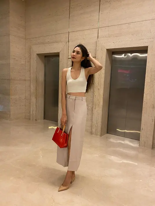 Dalam balutan tank top putih, dipadu dengan rok panjang berwarna cokelat muda, Mikha Tambayong tampil cantik memesona. Foto: Instagram.