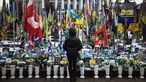 Seorang warga setempat berdiri di depan tugu peringatan sementara untuk tentara Ukraina di Lapangan Kemerdekaan, Kyiv, saat peringatan keempat invasi Rusia ke Ukraina, Selasa 24 Februari 2026. Hari ini, perang Rusia-Ukraina yang pecah pada 24 Februari 2022 telah berlangsung selama empat tahun. (HENRY NICHOLLS/AFP)