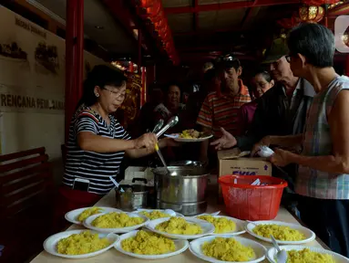 Pengurus Vihara Kim Tek Ie menyiapkan menu makan siang untuk pembeli warung nasi kuning Podjok Halal di Petak Sembilan, Jakarta, Selasa (24/12/2019). Warung Podjok Halal menjual nasi beserta lauk pauk dengan harga Rp 3.000. (merdeka.com/Imam Buhori)