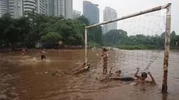 Anak-anak bermain di lapangan sepak bola di kawasan Kemang, Jakarta, Kamis (16/11). Tingginya intensitas hujan dan pesatnya pembangunan menyebabkan kawasan tersebut langganan banjir yang berasal dari luapan Kali Krukut. (Liputan6.com/Immanuel Antonius)
