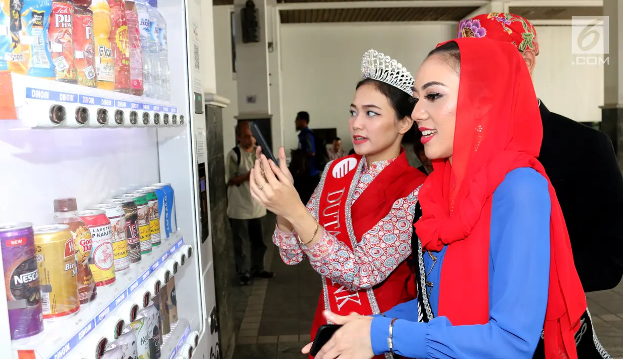 Duta Bank DKI Jakarta 2018, Nita Indriani memberikan edukasi layanan transaksi non tunai melalui aplikasi JakOne Mobile kepada finalis Abang None DKI Jakarta 2018 di Vending Machine Bank DKI di Balaikota, Jakarta  (26/07). (Liputan6.com/HO/Budi)