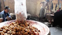 Pekerja dodol tampak memasukkan sejumlah gula merah ke dalam wadah besar, Jakarta, (16/7/14) (Liputan6.com/ Faizal Fanani)